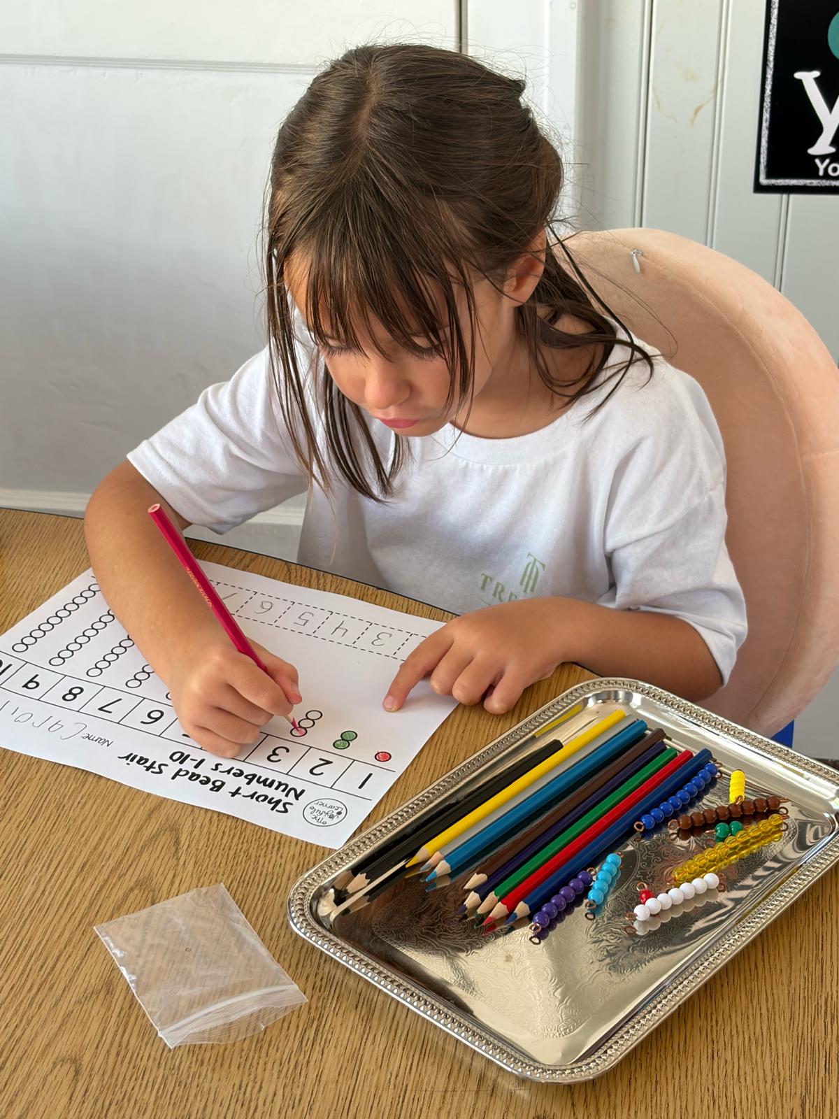 Young girl learning math with bead stair and number chart