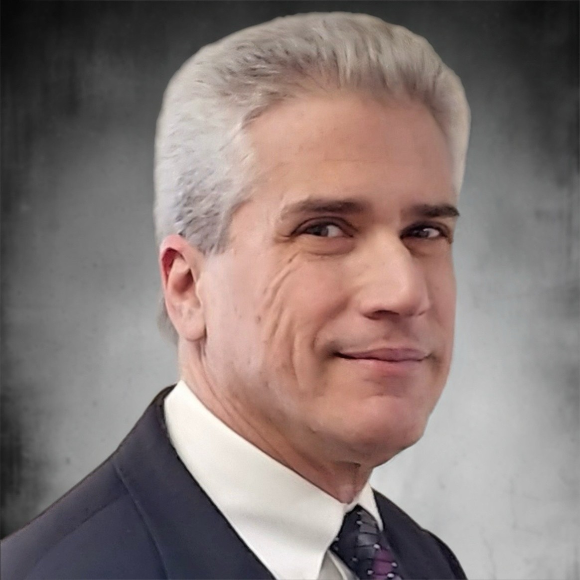 Stratton Vitikos in a suit, smiling confidently. Professional headshot.